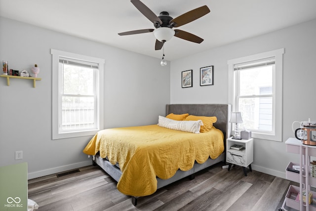 bedroom with visible vents, baseboards, and wood finished floors