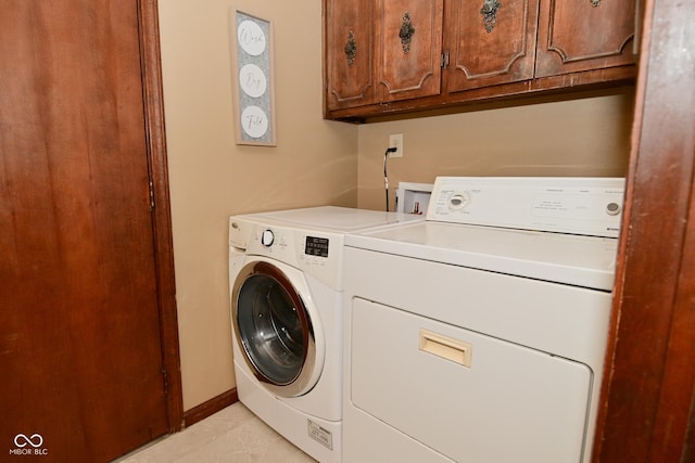 clothes washing area featuring cabinet space, baseboards, and independent washer and dryer