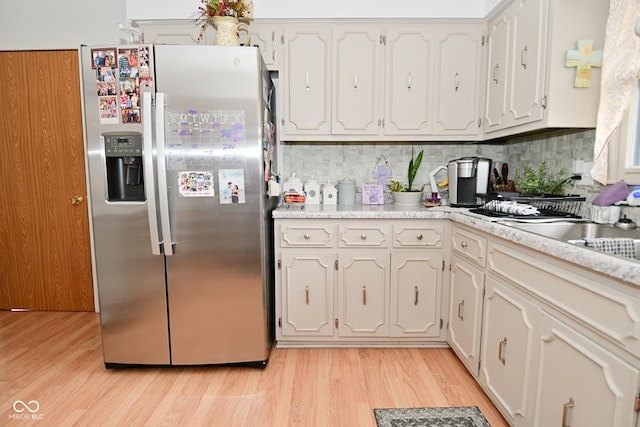 kitchen with light countertops, white cabinets, and stainless steel fridge