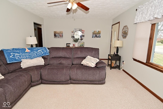 living room with a textured ceiling, carpet, a ceiling fan, and baseboards