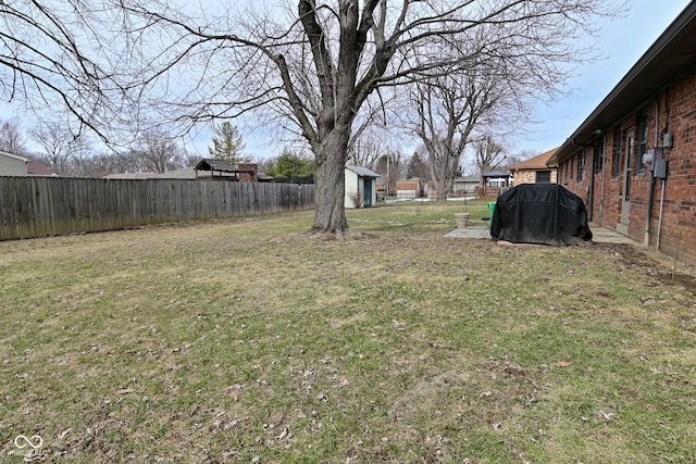 view of yard featuring a fenced backyard, an outdoor structure, and a shed