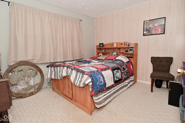 bedroom with baseboards, a textured ceiling, and light colored carpet