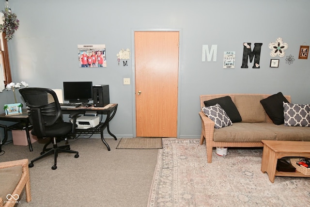 office area featuring light carpet and baseboards