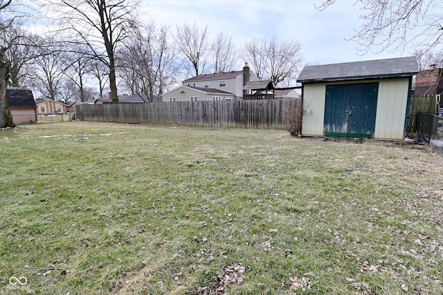 view of yard featuring a storage shed, an outdoor structure, and a fenced backyard