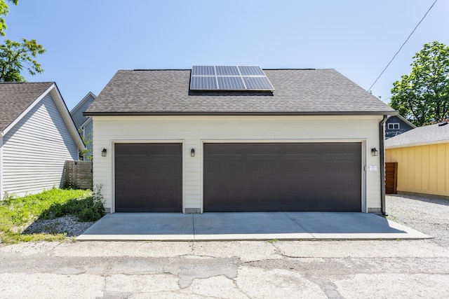 detached garage featuring solar panels