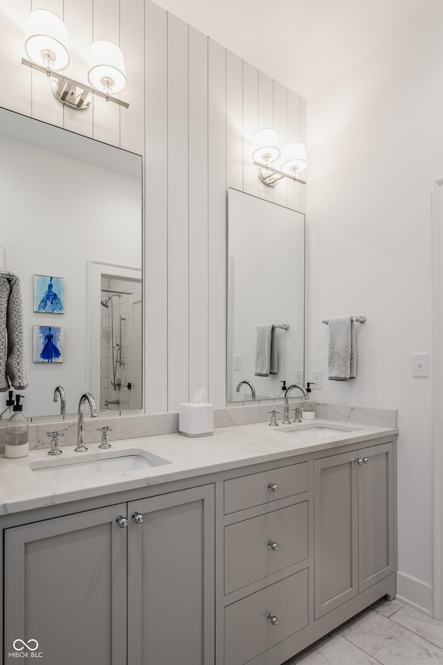 bathroom featuring an enclosed shower, marble finish floor, double vanity, and a sink