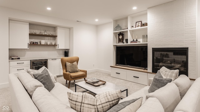 living room featuring recessed lighting, beverage cooler, light colored carpet, and a dry bar