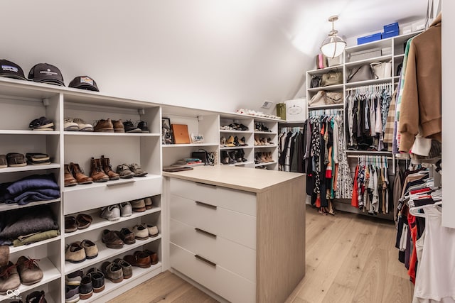 spacious closet with vaulted ceiling and light wood finished floors