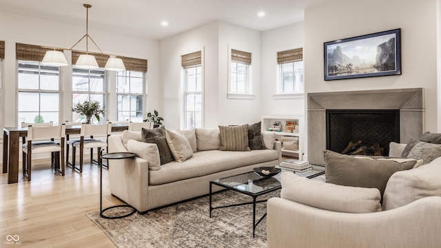 living area with light wood finished floors, a fireplace, and recessed lighting