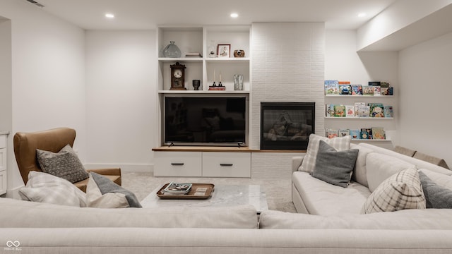 living area with a large fireplace, carpet, and recessed lighting