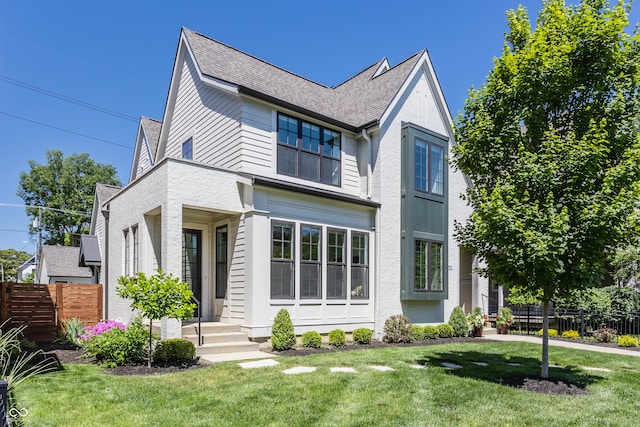 exterior space with a yard, fence, and a shingled roof