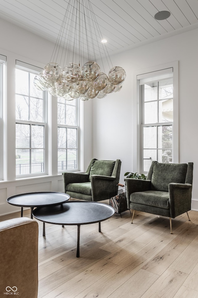 living area with light wood-type flooring and wooden ceiling