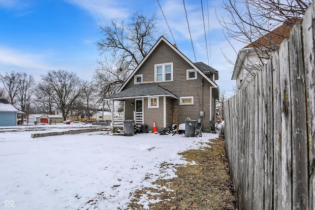 snow covered property featuring a shingled roof