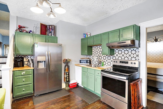 kitchen featuring dark wood-style flooring, stainless steel appliances, decorative backsplash, green cabinetry, and under cabinet range hood