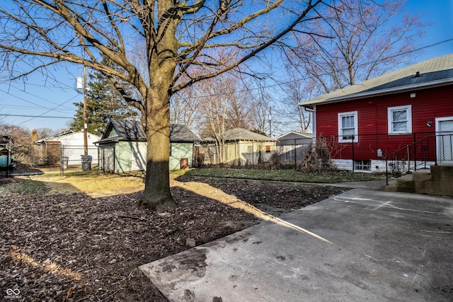 view of yard featuring an outdoor structure and fence