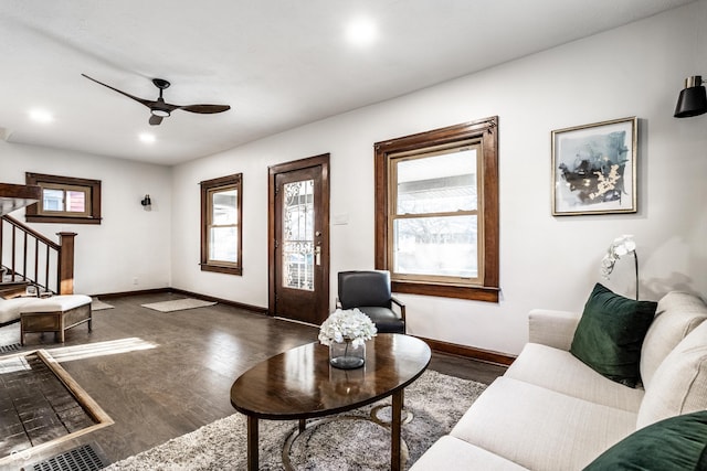 living area with a wealth of natural light, stairway, a ceiling fan, and wood finished floors