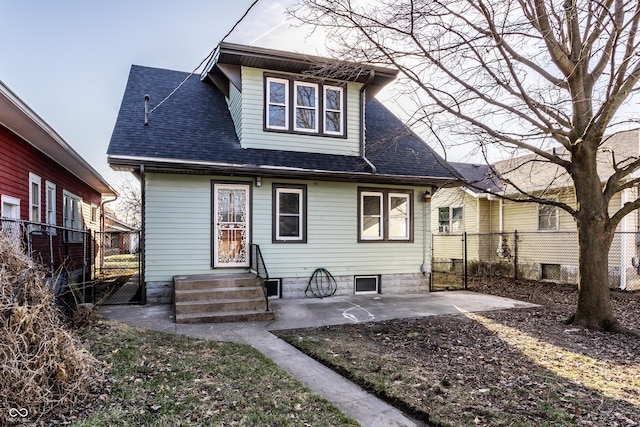 rear view of house with a patio area, fence, and a shingled roof