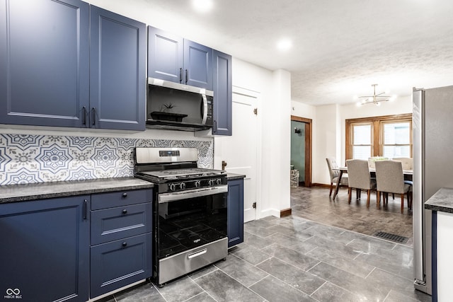 kitchen featuring backsplash, blue cabinetry, stainless steel appliances, and dark countertops