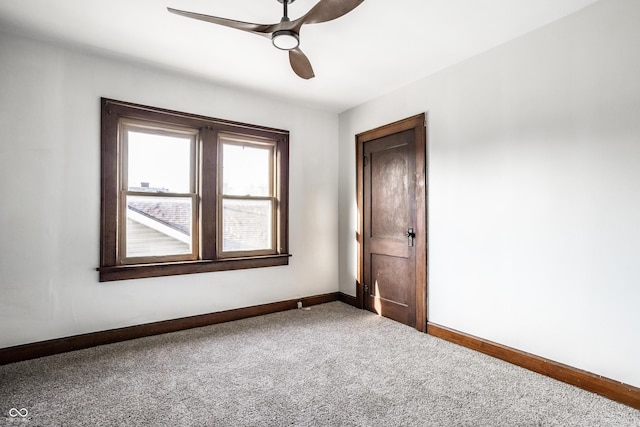 carpeted spare room with baseboards and ceiling fan