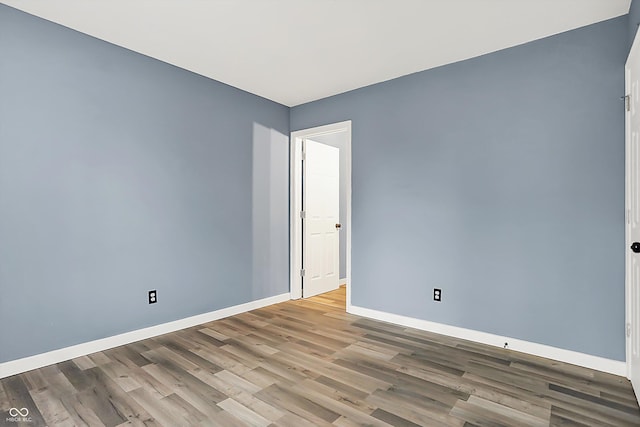 empty room with wood finished floors and baseboards