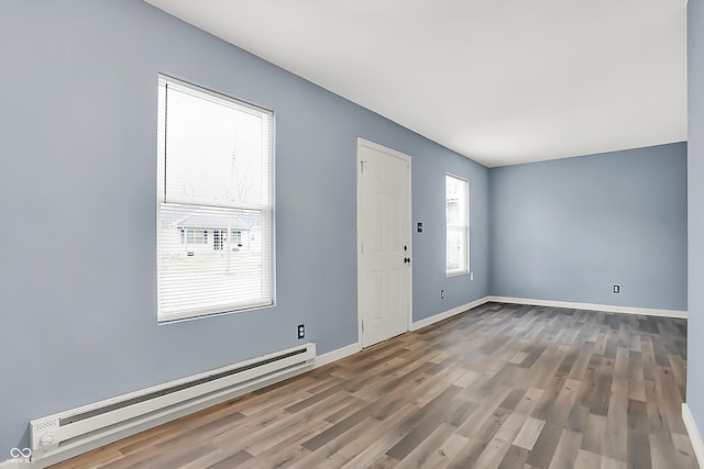 foyer with baseboards, baseboard heating, and wood finished floors