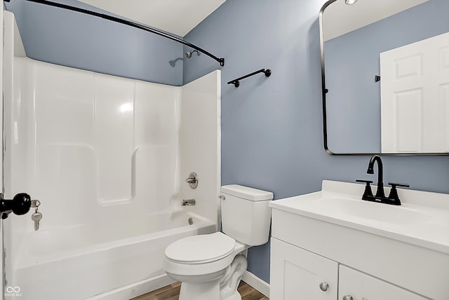 full bath with toilet,  shower combination, wood finished floors, and vanity