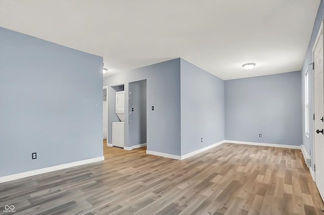 spare room featuring baseboards and light wood-style floors
