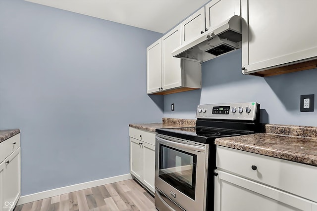 kitchen with light wood-style flooring, white cabinets, stainless steel electric range oven, and under cabinet range hood