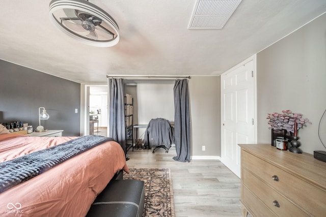 bedroom featuring light wood-type flooring, visible vents, and baseboards