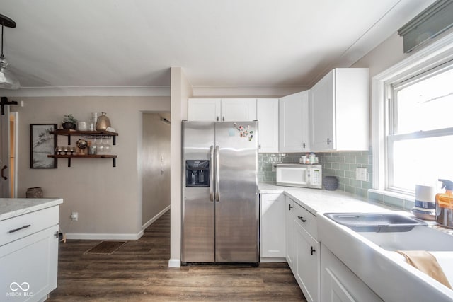 kitchen featuring white microwave, stainless steel refrigerator with ice dispenser, dark wood finished floors, and white cabinets