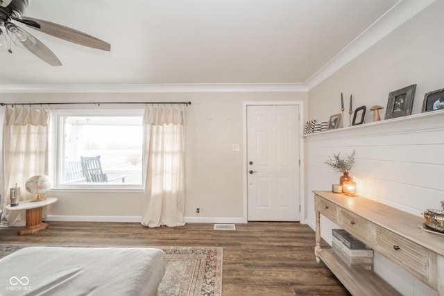 entryway with crown molding, visible vents, baseboards, and wood finished floors