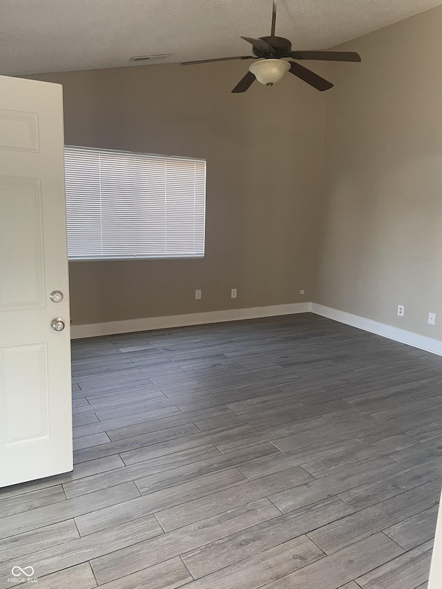 unfurnished room featuring ceiling fan, a textured ceiling, wood finished floors, and baseboards