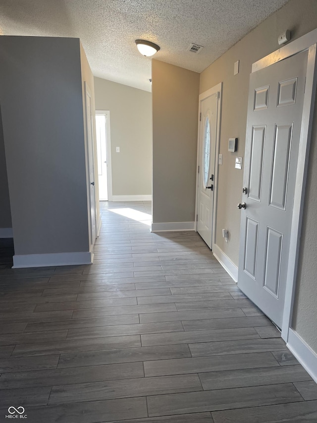 foyer featuring visible vents, dark wood finished floors, and baseboards