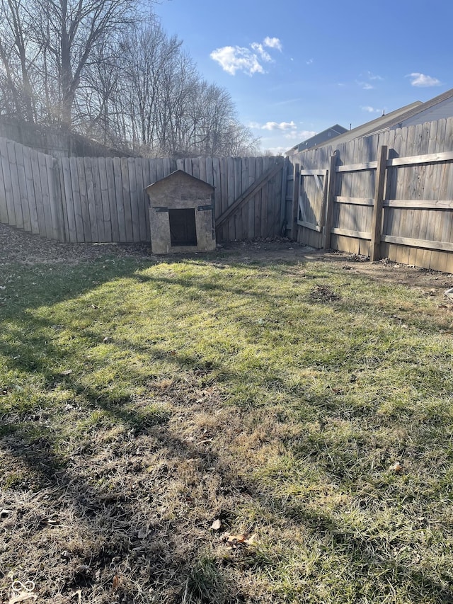 view of yard with an outbuilding, a storage unit, and a fenced backyard