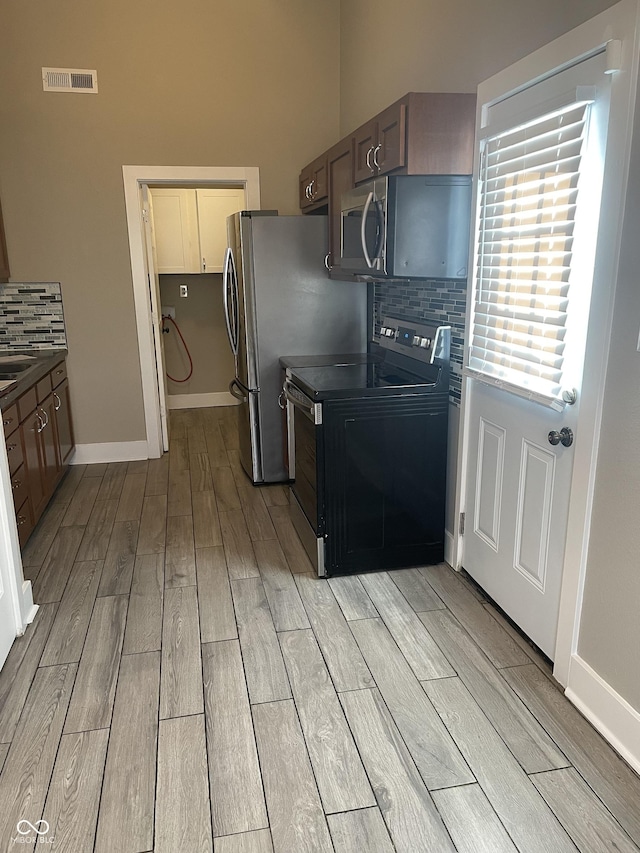 kitchen featuring tasteful backsplash, visible vents, baseboards, appliances with stainless steel finishes, and wood finish floors