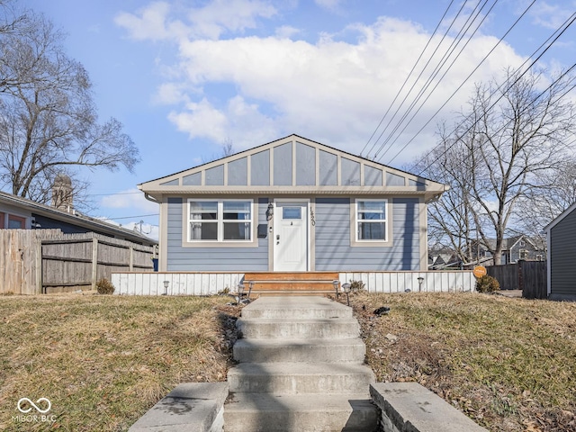 view of front of home featuring fence, board and batten siding, and a front yard