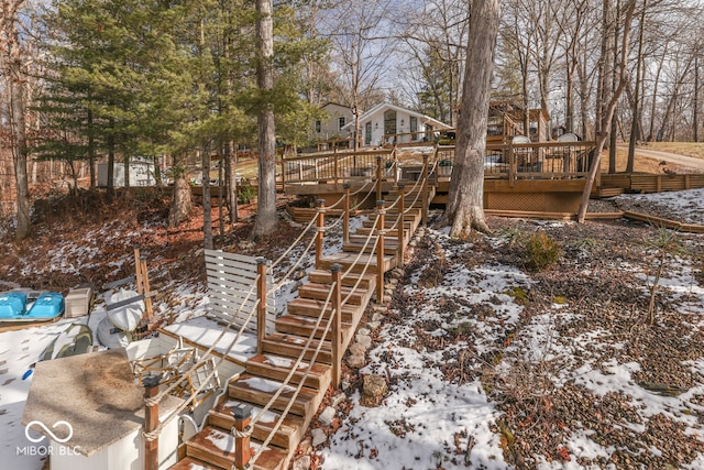 snowy yard featuring a deck and stairs