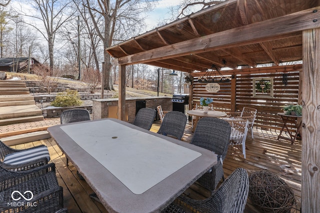 deck with outdoor dining area and a grill