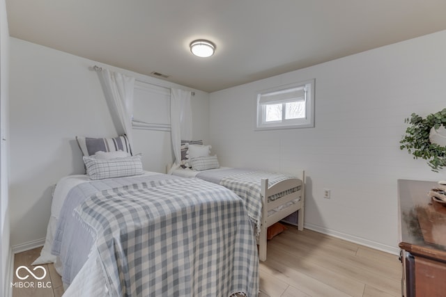 bedroom with light wood-type flooring, visible vents, and baseboards