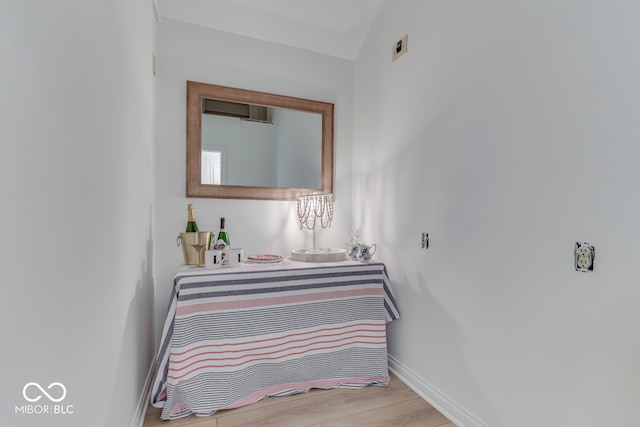 bedroom with light wood-style flooring, baseboards, and vaulted ceiling