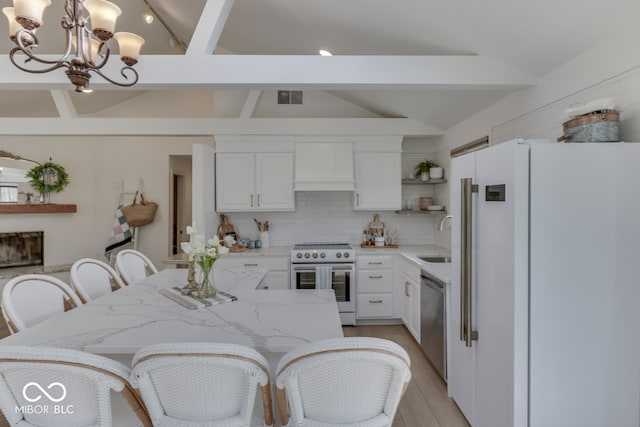 kitchen with open shelves, appliances with stainless steel finishes, decorative light fixtures, and white cabinets