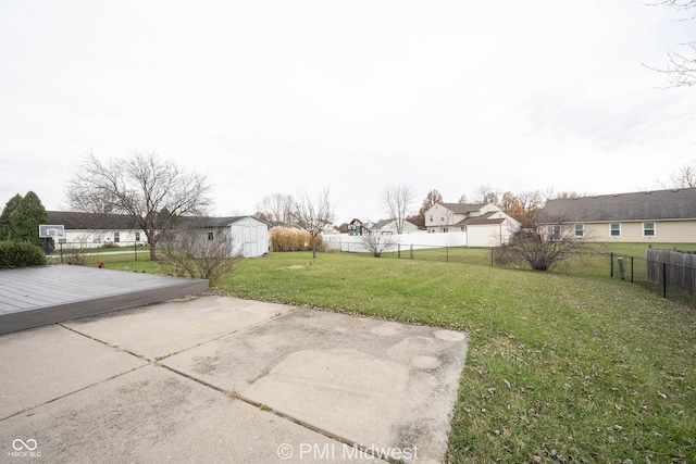 view of yard with a storage unit, a patio area, a residential view, a fenced backyard, and an outdoor structure