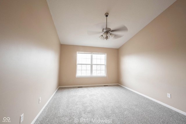 empty room featuring visible vents, a ceiling fan, vaulted ceiling, baseboards, and carpet