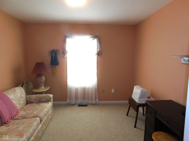 carpeted living area featuring visible vents and baseboards