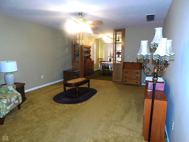 sitting room with baseboards, visible vents, dark carpet, and a ceiling fan