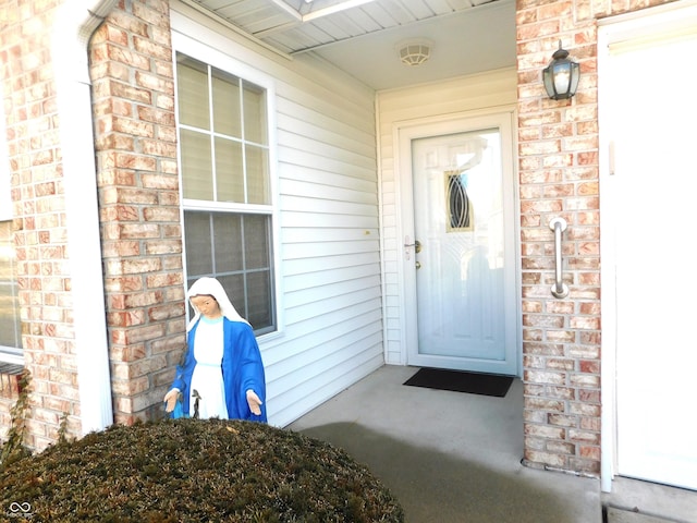 entrance to property with a garage and brick siding