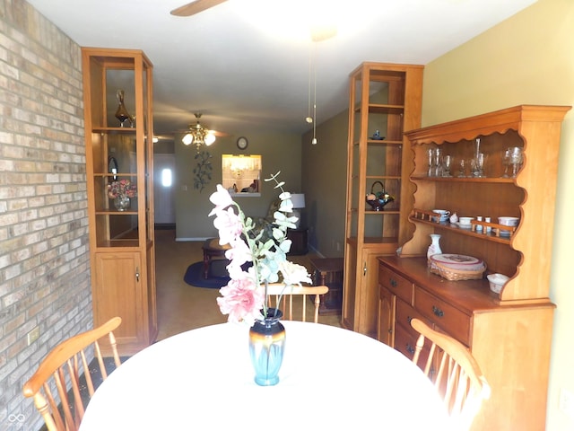 dining area with brick wall and a ceiling fan