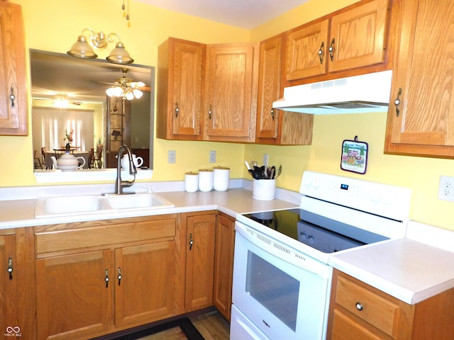 kitchen with light countertops, white electric range, a sink, and under cabinet range hood