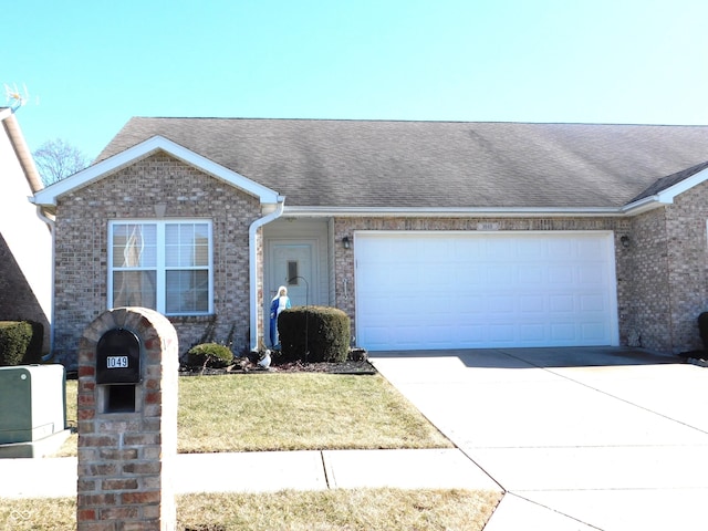 view of front of house with a garage, driveway, roof with shingles, and brick siding