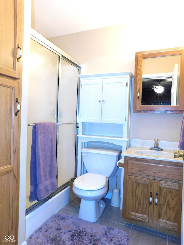 bathroom with toilet, a shower stall, vanity, and tile patterned floors